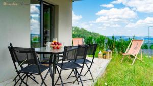 a table with a bowl of fruit on a patio at Wonder Home - Domki Hillside tuż przy stoku narciarskim - na terenie kompleksu plac zabaw i zewnętrzna siłownia, sklep, parking in Karpacz