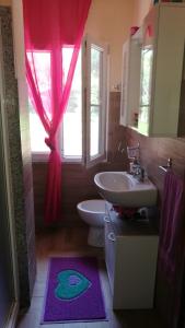 baño con lavabo y aseo y ventana en Villa Relax tra gli Ulivi, en Alghero