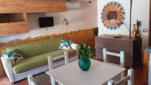 sala de estar con sofá y mesa en Villa Relax tra gli Ulivi, en Alghero