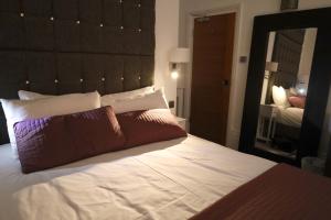 1 dormitorio con 1 cama grande y espejo grande en Brighton Inn Boutique Guest Accommodation, en Brighton & Hove