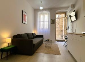 Zamaria Apartments في فيس: غرفة معيشة مع أريكة ومطبخ