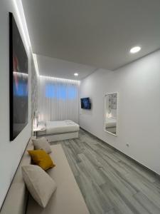 CH TANEZ CAROLINA a في مدريد: غرفة بيضاء مع سرير وأريكة