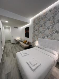 a white bedroom with a large bed and a couch at CH TANEZ CAROLINA a in Madrid