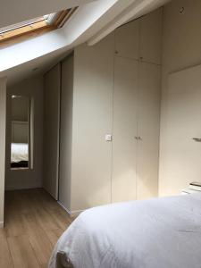 Charmante maison à 6 stations de métro paris centre في بري سور مارن: غرفة نوم بها دواليب بيضاء وسرير