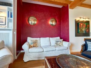 a living room with a white couch against a red wall at Fachwerkhäuser Seedorf - Villa "Johanna Maria" mit Kamin, Sauna, Terrasse, Wasserblick in Sandort