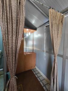 um quarto com uma cortina num quarto em Himvadi Resorts Kausani em Kausani