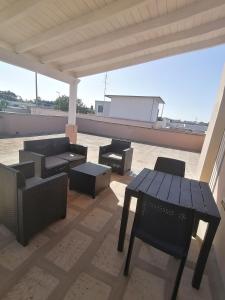 un patio con tavoli e sedie sul tetto di Gagliardo House a Taurisano