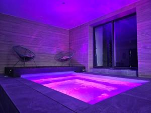 a hot tub in a room with purple lighting at Villa & Spa Luxuria in Massels