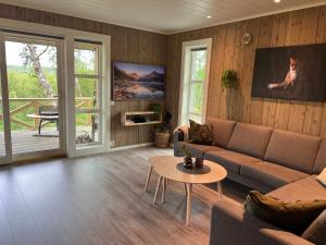 sala de estar con sofá y mesa en Olderfjord Lodge, en Russenes