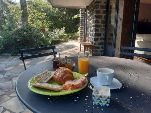 a table with a plate of food and a cup of coffee at Chambres d'hôtes La Tour de Bellevue et son jacuzzi in Saumur