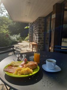 a plate of breakfast food on a table with orange juice at Chambres d'hôtes La Tour de Bellevue in Saumur