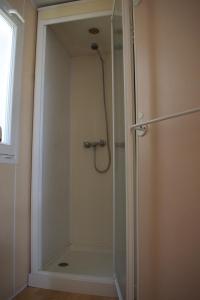 y baño con ducha y puerta de cristal. en Mobile Home Etang II, en Chiddes