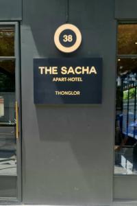 um sinal para o hotel de apartamentos saachi numa parede em The SACHA Apart-Hotel Thonglor em Banguecoque