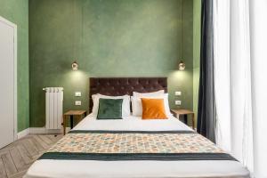 ローマにあるRipetta Executive Suitesの緑の壁のベッドルーム1室(大型ベッド1台付)