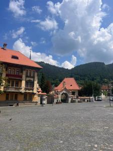 a town square with a building and a mountain at Pension Old City in Braşov