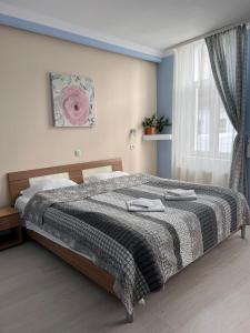 a bedroom with a large bed with a blanket at Pension Old City in Braşov