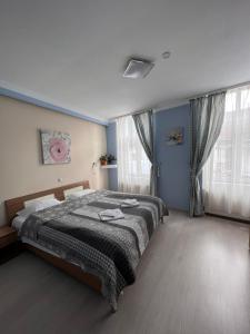 a bedroom with a bed and a large window at Pension Old City in Braşov