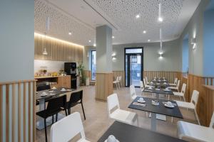 a restaurant with tables and chairs and a kitchen at Plaza de la Luz Cádiz in Cádiz