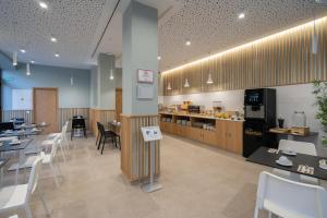 un restaurant avec des tables, des chaises et un comptoir dans l'établissement Plaza de la Luz Cádiz, à Cadix