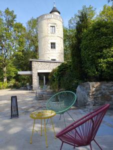 un gruppo di sedie e un tavolo di fronte a un faro di Chambres d'hôtes La Tour de Bellevue a Saumur