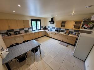 a large kitchen with a table and chairs in it at Résidence de la gare, chambre meublée in Longjumeau