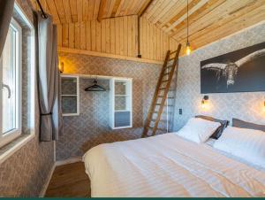 a bedroom with a bed and a ladder on the wall at Le chalet de pépère in Stavelot