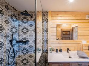 ein Bad mit einer Dusche, einem Waschbecken und einem Spiegel in der Unterkunft Le chalet de pépère in Stavelot