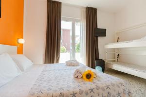 里米尼的住宿－聖雷莫酒店，一间卧室配有一张床,上面有向日葵