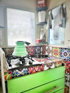 una cocina con fogones y un tazón verde. en Baby Blue Houseboat, en Port Edward
