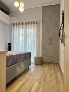 a bedroom with a bed and a large window at Loutraki apARTment in Loutraki