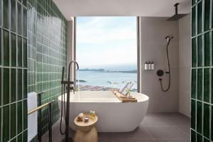 a bathroom with a tub with a view of the ocean at The Yacht Hotel by DC in Ha Long