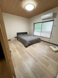 a bedroom with a bed and a window in it at ABC accommodation in Osaka