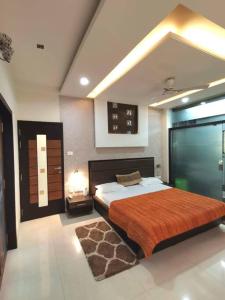 um quarto com uma cama grande e um cobertor laranja em OM SHAKTI em Belgaum