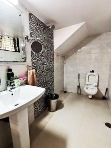 uma casa de banho com um lavatório e um WC em OM SHAKTI em Belgaum
