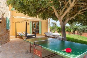 una mesa de ping pong en un patio con un árbol en Finca Ses Mires, en Cala Santanyi