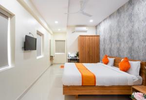 1 dormitorio con 1 cama y TV en la pared en Iris at Nest, en Hyderabad