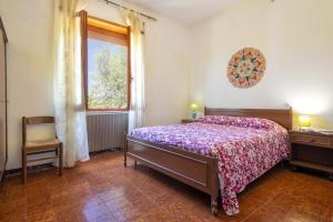 sypialnia z łóżkiem, oknem i krzesłem w obiekcie Spacious home in Costa Rossa w mieście Trinità dʼAgultu