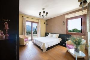 una camera da letto con un letto, un divano e una finestra di Villa Oneirodromio a Kato Korakiana