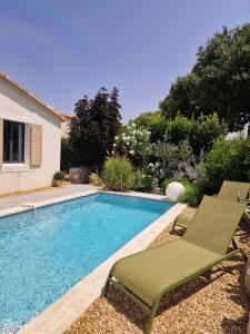 uma piscina com duas espreguiçadeiras ao lado de uma casa em Magnifique Villa avec Piscine en Provence em Verquières