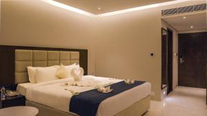 a bedroom with a large bed with towels on it at Mayur Belgaum Presidency Hotel & Spa in Belgaum