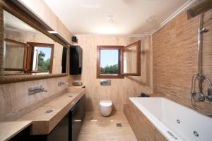 bagno con vasca, servizi igienici e finestre di Villa Oneirodromio a Kato Korakiana Altre 31 foto