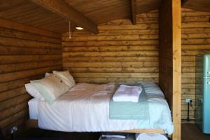 um quarto com uma cama num chalé de madeira em Knapp Farm Glamping Lodge 2 em Corscombe