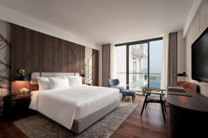 sypialnia z dużym białym łóżkiem i biurkiem w obiekcie The Yacht Hotel by DC w Ha Long