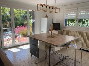 a kitchen with a table and chairs and a television at Une pause au paradis in Sorgues