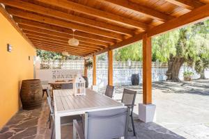 un patio avec une table et des chaises sous un toit en bois dans l'établissement Un lugar en el mundo, à Tegueste