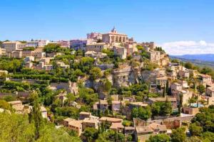 a town on top of a hill with houses at Une pause au paradis in Sorgues