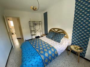 a bedroom with a blue and white bed and a table at Une pause au paradis in Sorgues +42 photos