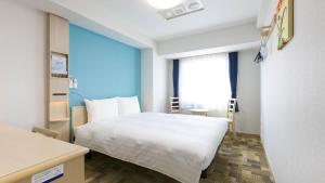 a bedroom with a white bed and a large window at Toyoko Inn Tokyo Keio-sen Higashi-fuchu-eki Kita-guchi in Fuchu