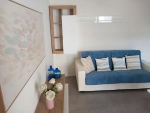 un soggiorno con divano blu e tavolo di Luxury home near the Beach private parking space ad Alghero