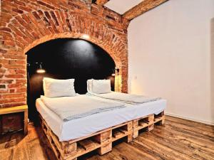 a bed in a room with a brick wall at CityNest Apartments in Kraków